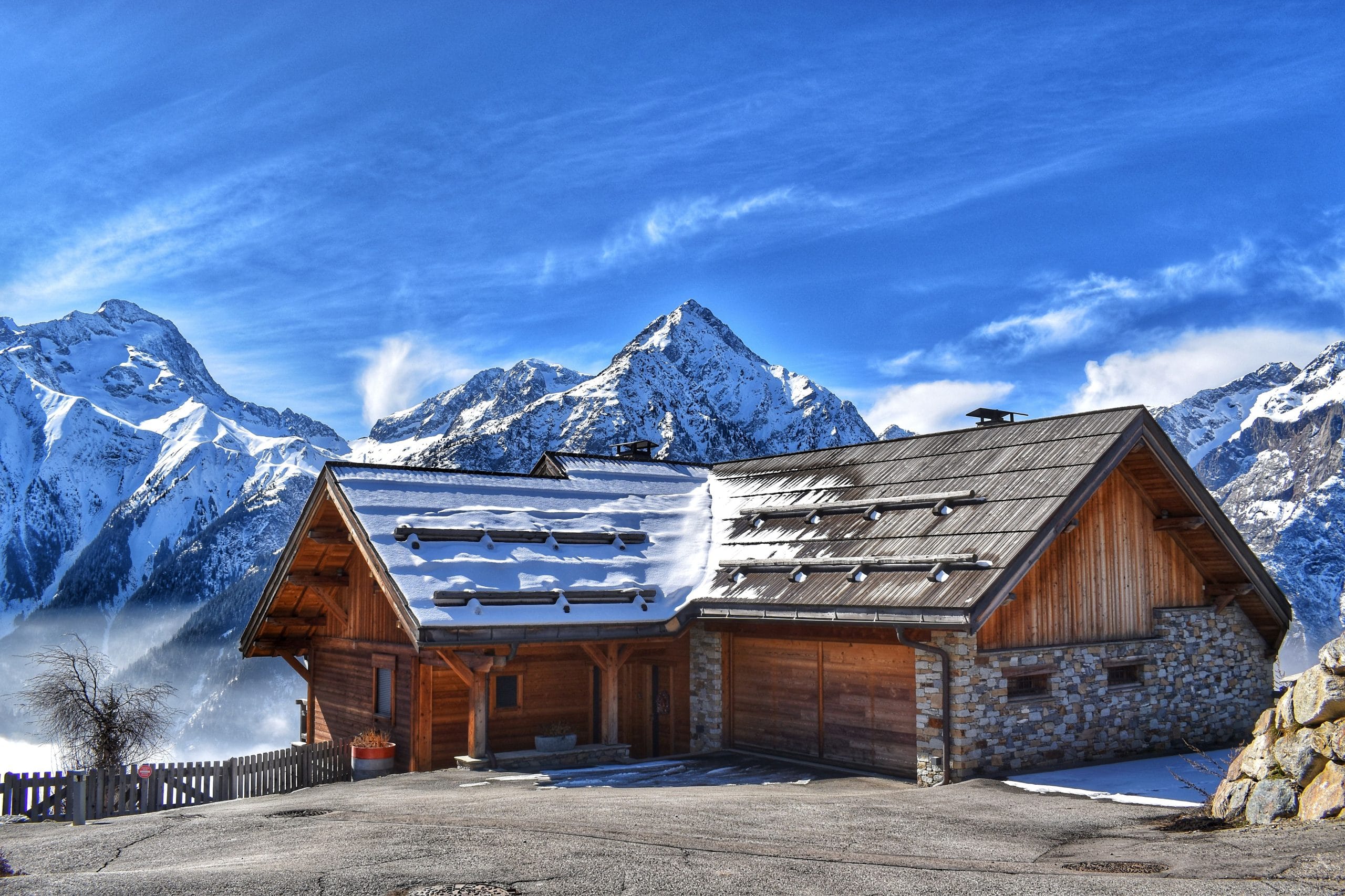 An elegant exterior of luxury mountain lodges overlooking a cinematic mountain range