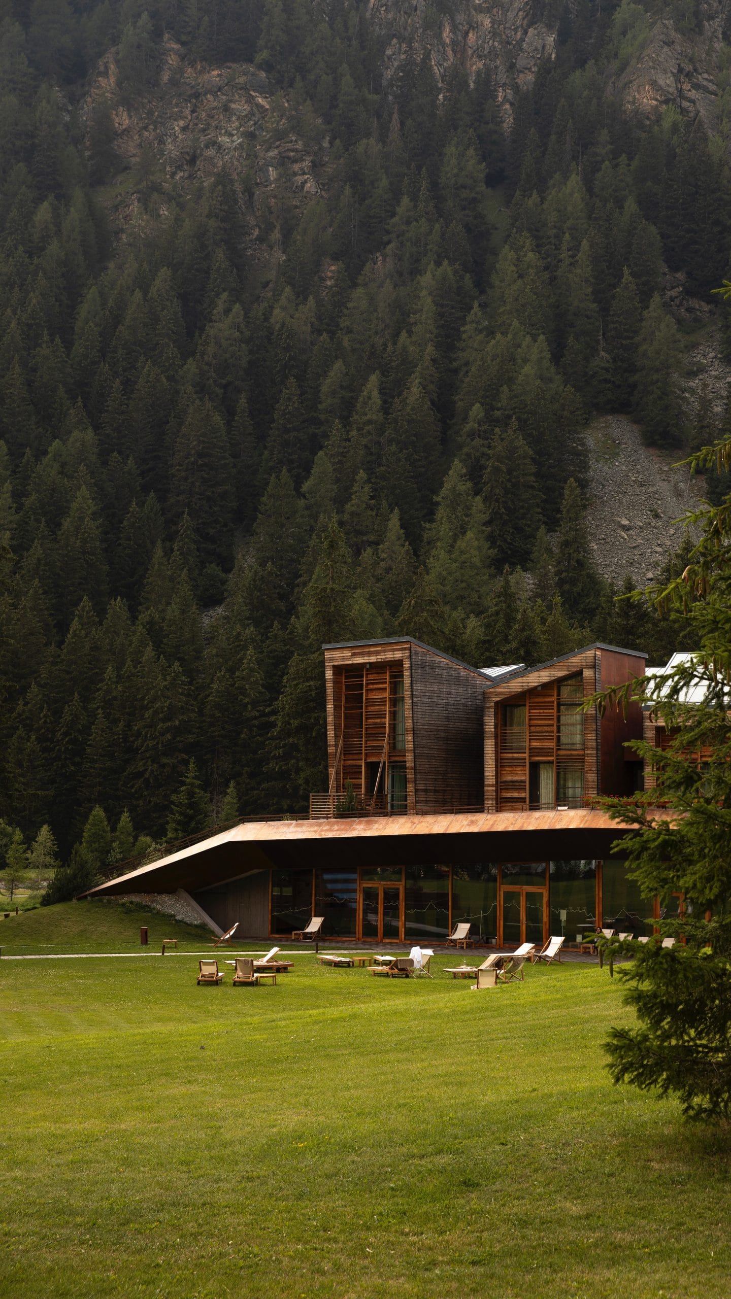 An elegant exterior of luxury mountain lodges overlooking a cinematic mountain range